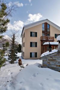 uma casa com neve em frente em Chesa Roser - Samedan em Samedan