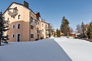 a snow covered street in front of a building at Chesa Roser - Samedan in Samedan