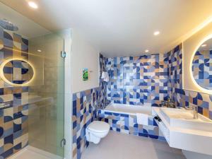 y baño con aseo, lavabo y ducha. en Novotel Monte-Carlo en Montecarlo