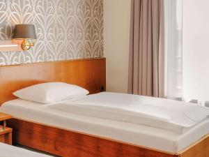 Postel nebo postele na pokoji v ubytování Mercure Hotel Trier Porta Nigra