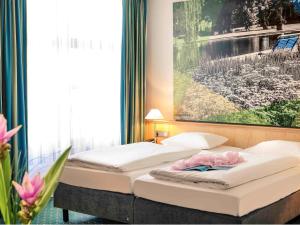 A bed or beds in a room at Mercure Hotel Erfurt Altstadt