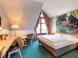 A bed or beds in a room at Mercure Hotel Erfurt Altstadt
