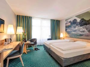 A bed or beds in a room at Mercure Hotel Erfurt Altstadt