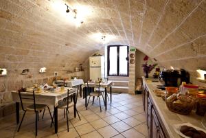 una cocina con mesas y sillas en una habitación en B&B Casa Cimino - Monopoli - Puglia, en Monopoli