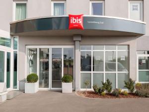 un edificio con un cartello di alto sulla parte anteriore di ibis Luxembourg Sud a Livange