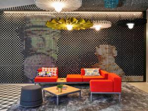 a living room with a red couch and a table at Ibis Barcelona Plaza Glòries 22@ in Barcelona