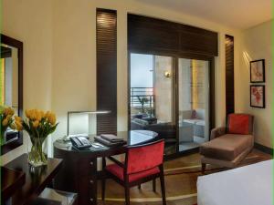 uma sala de estar com uma secretária e uma cadeira e um quarto em Sofitel Al Khobar The Corniche em Al Khobar