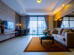 sala de estar con sofá y mesa en Grand Mercure Bangkok Asoke Residence, en Bangkok