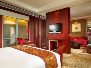 a hotel room with a bed and a tv at Sofitel Nanjing Galaxy in Nanjing