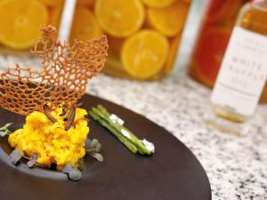 a plate of food on a counter with orange juice at Novotel Hyderabad Convention Centre in Hyderabad