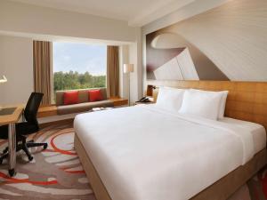 a hotel room with a large bed and a desk at Novotel Hyderabad Convention Centre in Hyderabad