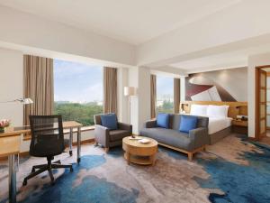 a hotel room with a bed and a desk at Novotel Hyderabad Convention Centre in Hyderabad