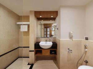a bathroom with a sink and a mirror at Novotel Hyderabad Convention Centre in Hyderabad