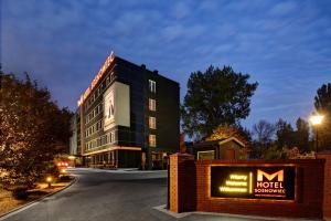 un hotel con un cartel frente a un edificio en M Hotel Sosnowiec, en Sosnowiec