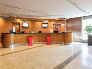 a lobby with a waiting room with red chairs at Ibis Ambassador Myeongdong in Seoul