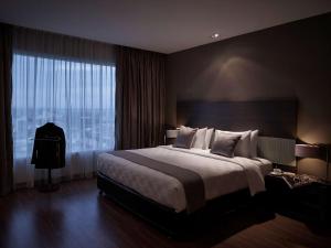 Ένα ή περισσότερα κρεβάτια σε δωμάτιο στο Pullman Kuching