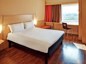 a large bed in a room with a window at ibis Campo Grande in Campo Grande