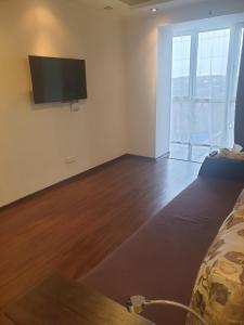カームヤネツィ・ポジーリシクィイにあるElena's Holiday Apartmentのベッド1台、壁掛け式薄型テレビが備わる客室です。