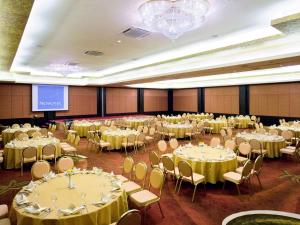 a banquet hall with tables and chairs and a screen at The Nouveau Chumphon Beach Resort And Golf in Chumphon