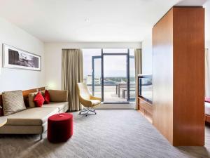 
a living room filled with furniture and a window at Novotel Christchurch Cathedral Square in Christchurch
