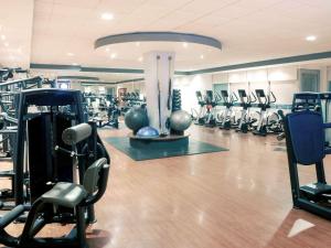 a gym with lots of treadmills and exercise equipment at Mercure Cardiff Holland House Hotel & Spa in Cardiff