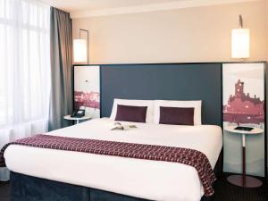 カーディフにあるメルキュール カーディフ ホーランド ハウス ホテル＆スパの大きなベッドと窓が備わるホテルルームです。