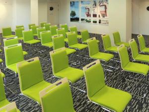 a room with green chairs in a classroom at Mercure Granville Le Grand Large in Granville