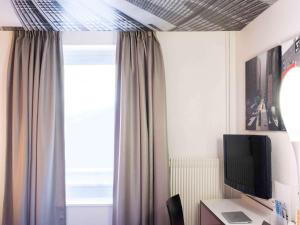 A television and/or entertainment centre at Ibis Styles Strasbourg Centre Gare