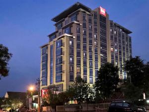 een hoog gebouw met een bord aan de zijkant bij Hotel Ibis Semarang Simpang Lima in Semarang