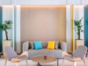 芭东海滩Ibis Phuket Patong的客厅里有一张沙发和两把椅子