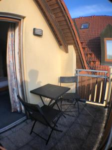 - Balcón con mesa y 2 sillas en Apartment Hotel Seebach en Großenseebach