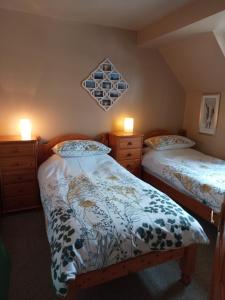 a bedroom with two beds and two dressers at Strome Beag in Tobermory