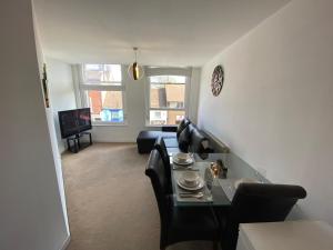 a living room with a couch and a table and chairs at Cosy One Bedroom Apartment in Worcester