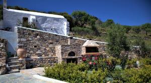 a stone building with a stone oven in a garden at St.George Valsamitis in Katapola