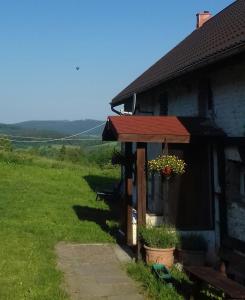 una casa con una maceta al lado de ella en Dziki domek, en Sierpnica