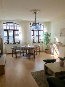 a living room with a table and chairs and windows at Altstadt-Refugium in Hameln