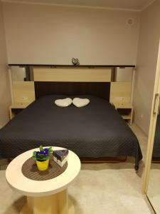 Un dormitorio con una cama y una mesa con un pastel en Cerību Liedags, en Mērsrags