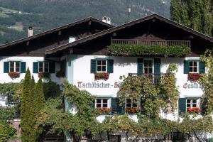 une maison blanche avec volets verts et lierre dans l'établissement Gasthof Tschötscherhof, à Castelrotto