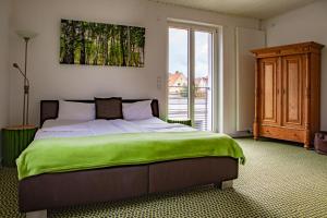a bedroom with a large bed with a green blanket at Hotel Kolb in Zeil
