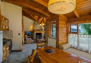 a kitchen and dining room with a table in a cabin at Nido del Cóndor Hotel & Spa in San Carlos de Bariloche