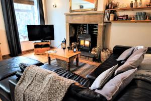 a living room with a couch and a fireplace at Mulberry Cottage in Haworth
