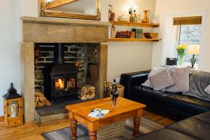 ein Wohnzimmer mit Couch und Kamin in der Unterkunft Mulberry Cottage with Wood Burner, Garden and Easy Parking in Haworth + 35 Fotos