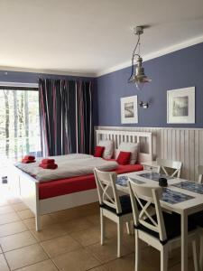 1 dormitorio con 1 cama y 1 mesa con sillas en Villa Park & Plaża, en Świnoujście
