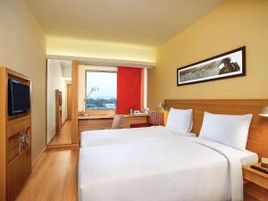 a hotel room with two beds and a television at ibis Bengaluru Hosur Road - An Accor Brand in Bangalore