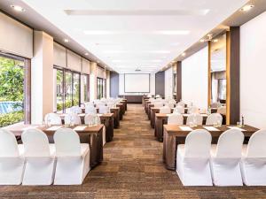 a conference room with tables and white chairs at Ibis Bangkok Riverside in Bangkok