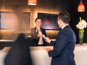 un homme et une femme debout devant un miroir dans l'établissement Mercure Lyon Centre - Gare Part Dieu, à Lyon