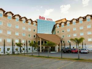 ヴィトリア・ダ・コンキスタにあるibis Vitoria da Conquistaの目の前にホテルの看板が立つ大きな建物