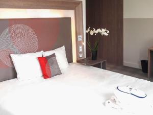 a bedroom with a large bed with two pillows at Novotel SPA Rennes Centre Gare in Rennes