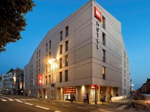 un grande edificio bianco su una strada di città di notte di ibis Sint Niklaas Centrum a Sint-Niklaas