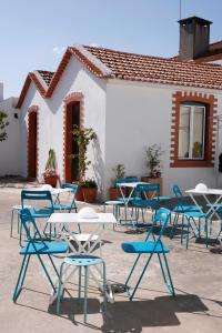a patio area with chairs, tables and umbrellas at Santarem Hostel in Santarém